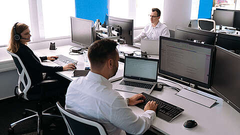 IT-Hardware von OCTO IT Mitarbeitende von OCTO IT sitzen am Arbeitsplatz