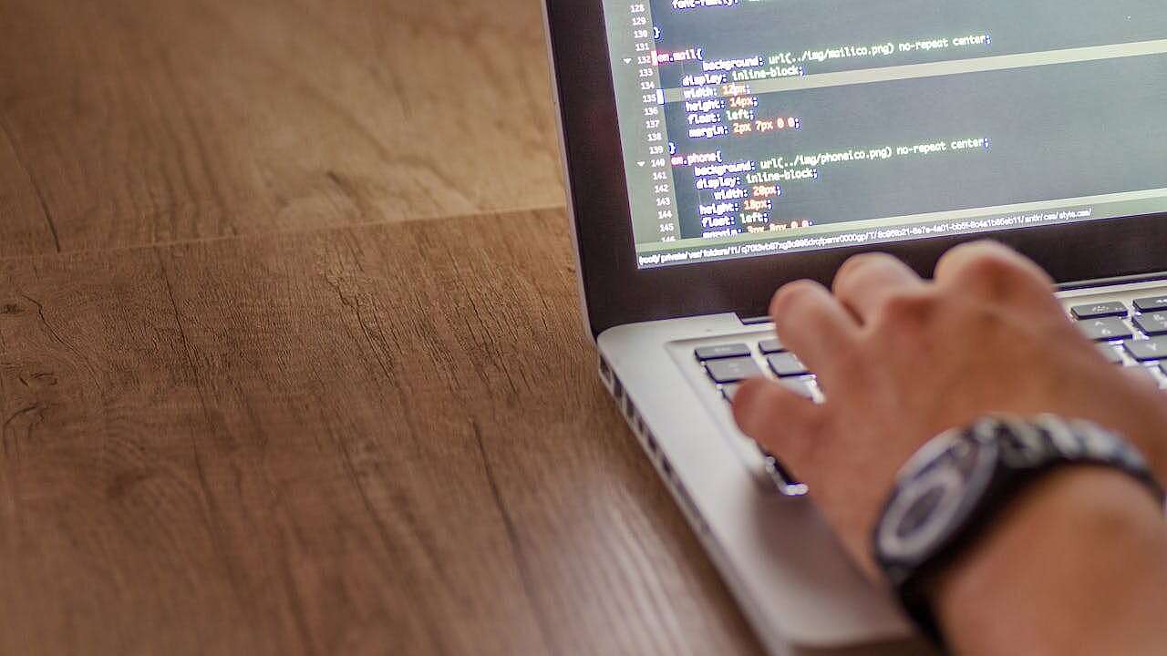 Ein IT-Mitarbeiter schreibt Code an seinem Notebook